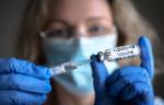 Woman holds Covid-19 vaccine in hands.