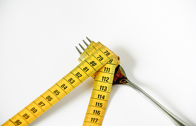 Measuring tape wrapped around a fork