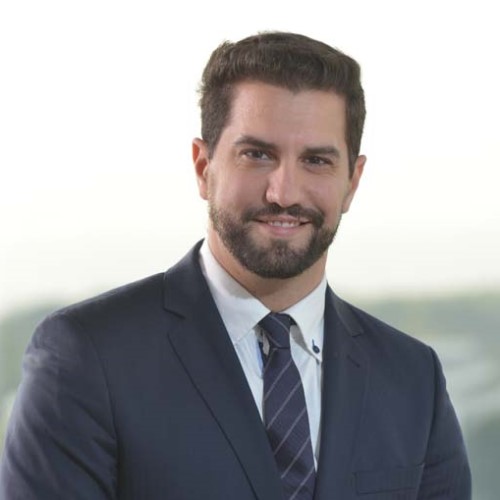 Headshot of alumnus, Emmanuel Artusa-Barrell. He is smiling and wearing a suit and tie.