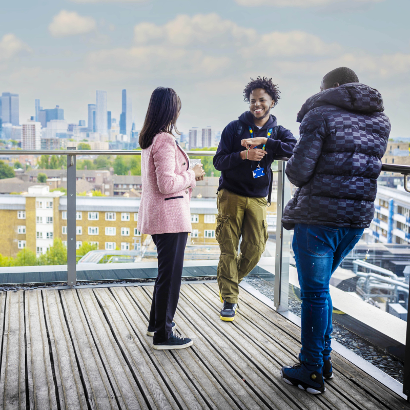 Students talking in front of city of London skyscrapers