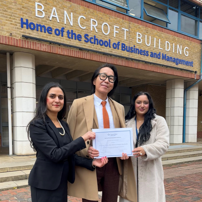 Three members of SBM staff in front of the SBM building.