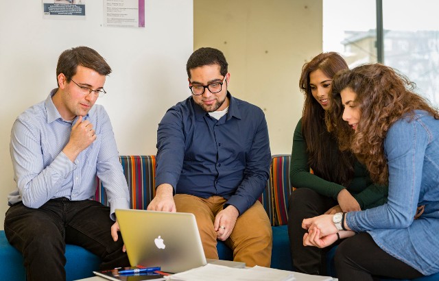 Students sitting around laptop