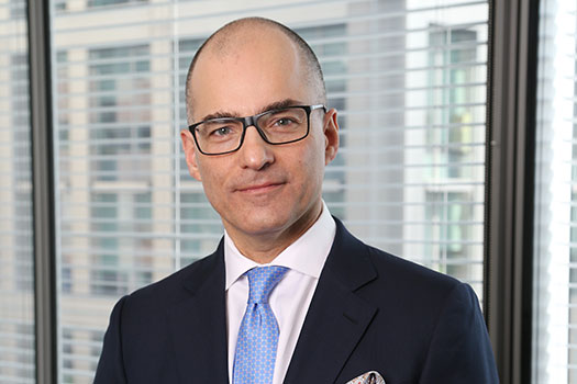 Domenico Di Pietro in a suit wearing glasses