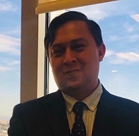 CCLS Colombia chapter organiser German Dario Florez Acero standing in front of a window with view of blue sky