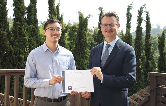 Cody Wong receiving his award for the essay prize from Professor Duncan Matthews