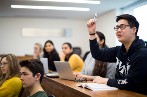 Queen Mary LLB student with raised hand in lecture