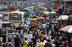 A bustling street in Ghana with people, market stalls and busy road