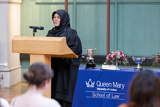 Student in a headscarf standing at a podium during the 2022 George Hinde Moot