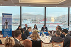 Professor Miriam Goldby and Dr Filip Saranovic on a panel in the Hellenic Management Centre. Behind them is the port of Piraeus.