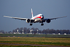 Plane landing on a runway surrounded by grass