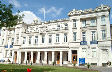 The facade of the Queens' Building on a sunny day