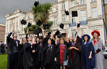 LLM in Paris students throwing graduation caps after ceremony