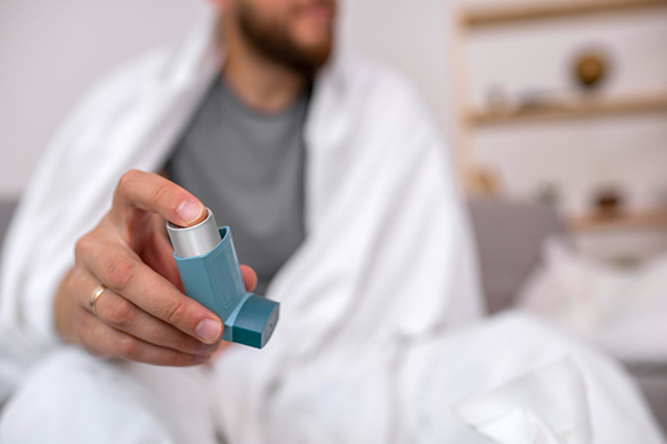 Young adult holding a blue inhaler