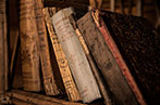 Old, worn books arranged on a shelf