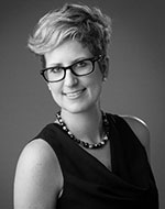 Black and white photo of Esther van Zimmeren. She is wearing a black dress and glasses.