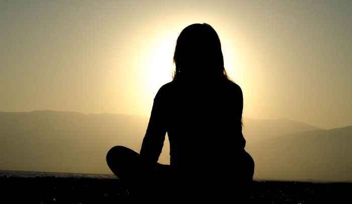 image of a woman who sits meditating