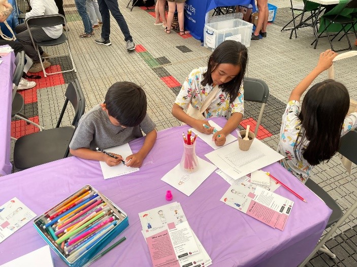 Image of kids doing the Draw yourself as a scientist activity at the WISE stall during the 2022 Festival of Communities