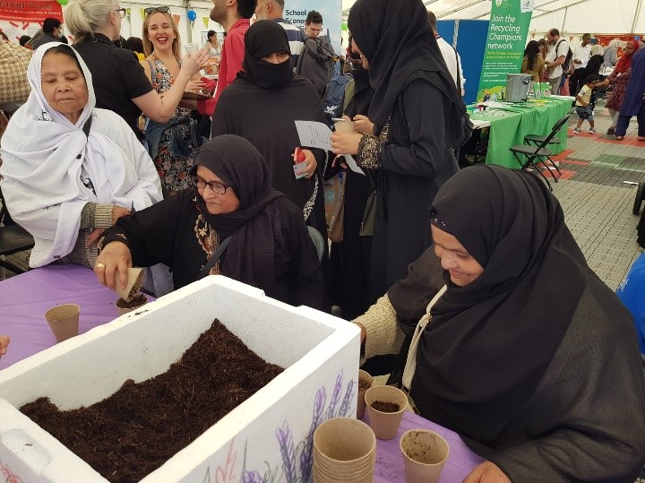 People at the WISE staff during the 2022 Festival of Communities doing the plant your own sunflower seeds activity