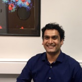 A photo of Sabari Vallath standing in front of a scientific picture