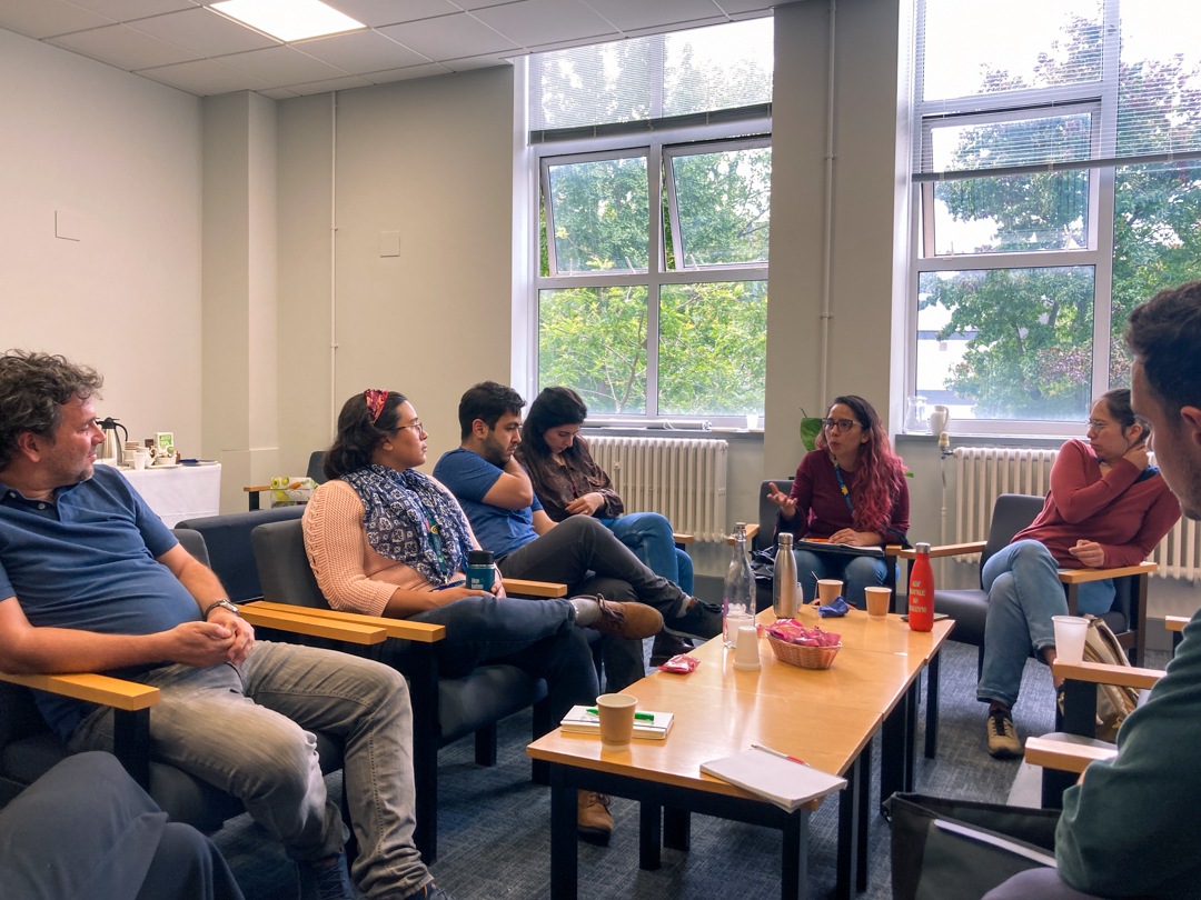 A photo of people engaged in discussion, sitting around a table