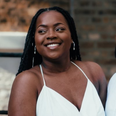 Headshot of alumna, Teni Gogo. She is wearing a white vest top and is smiling.