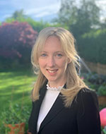 Lisa McClory, smiling and standing in a garden