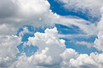 A blue sky with big white fluffy clouds