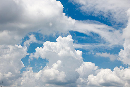 A blue sky with big white fluffy clouds