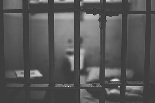 A black and white photo of prison cell bars