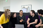 Queen Mary Law students gathered round a laptop in the graduate centre