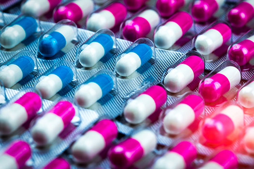 Pink and blue capsules in sealed packets