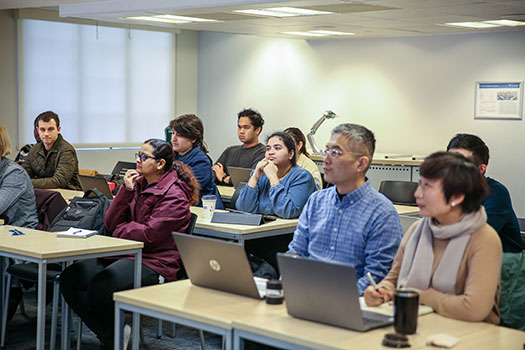 Queen Mary LLM students sitting in a seminar with laptops.