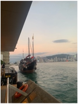 Waterfront with a large boat and mountains on the background