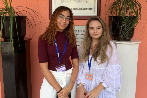 Idhil Jama and Alexandra Tanase standing in front of an orange wall in Trinidad and Tobago 