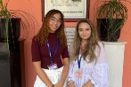 Idhil Jama and Alexandra Tanase standing in front of an orange wall in Trinidad and Tobago