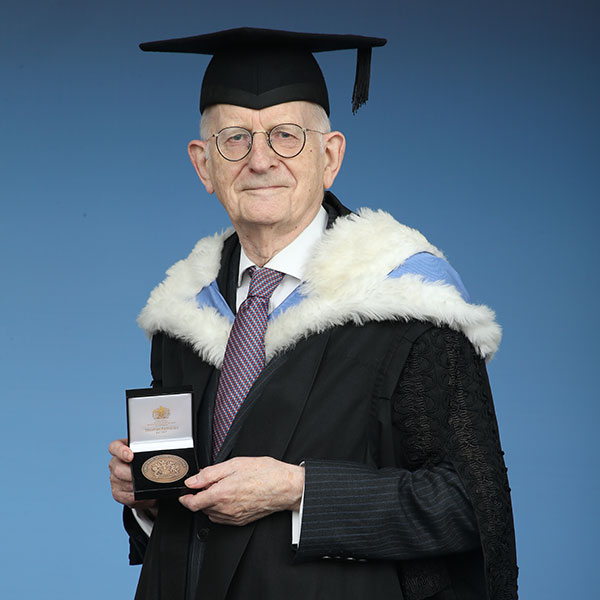 Ian Yeats in academic robes and holding his Queen Mary Medal