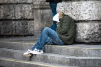 Homeless person on huddled up from the cold on the steps of building