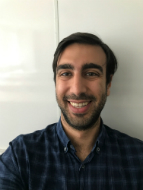 Head and shoulders shot of Andreas Marcou. A smiling man with olive skin, short dark hair and a short beard.