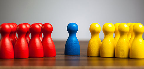 A group of red pawns facing a group of yellow pawns with a blue pawn in the middle