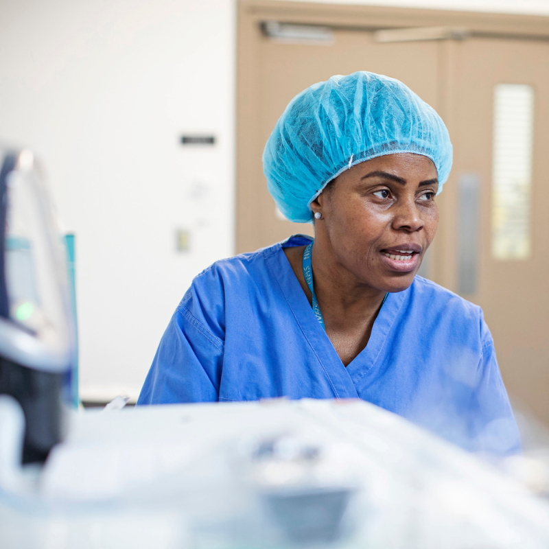 A nurse standing over a hospital bed