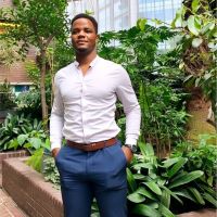 David Ajibade standing in a conservatory in front of plants