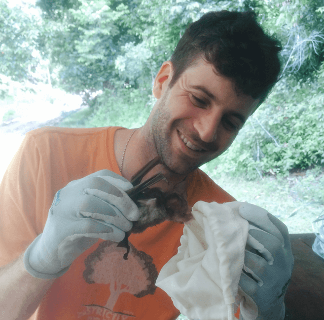 Alumnus David Hemprich-Bennett holding a bat as part of his PhD research