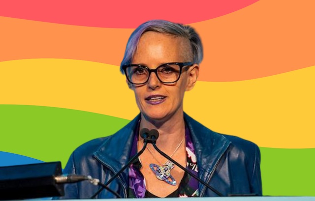 Professor Chloe Orkin speaking against rainbow backdrop