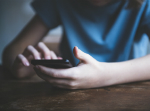 Boy using phone. Credit: Rouzes/ iStock.com