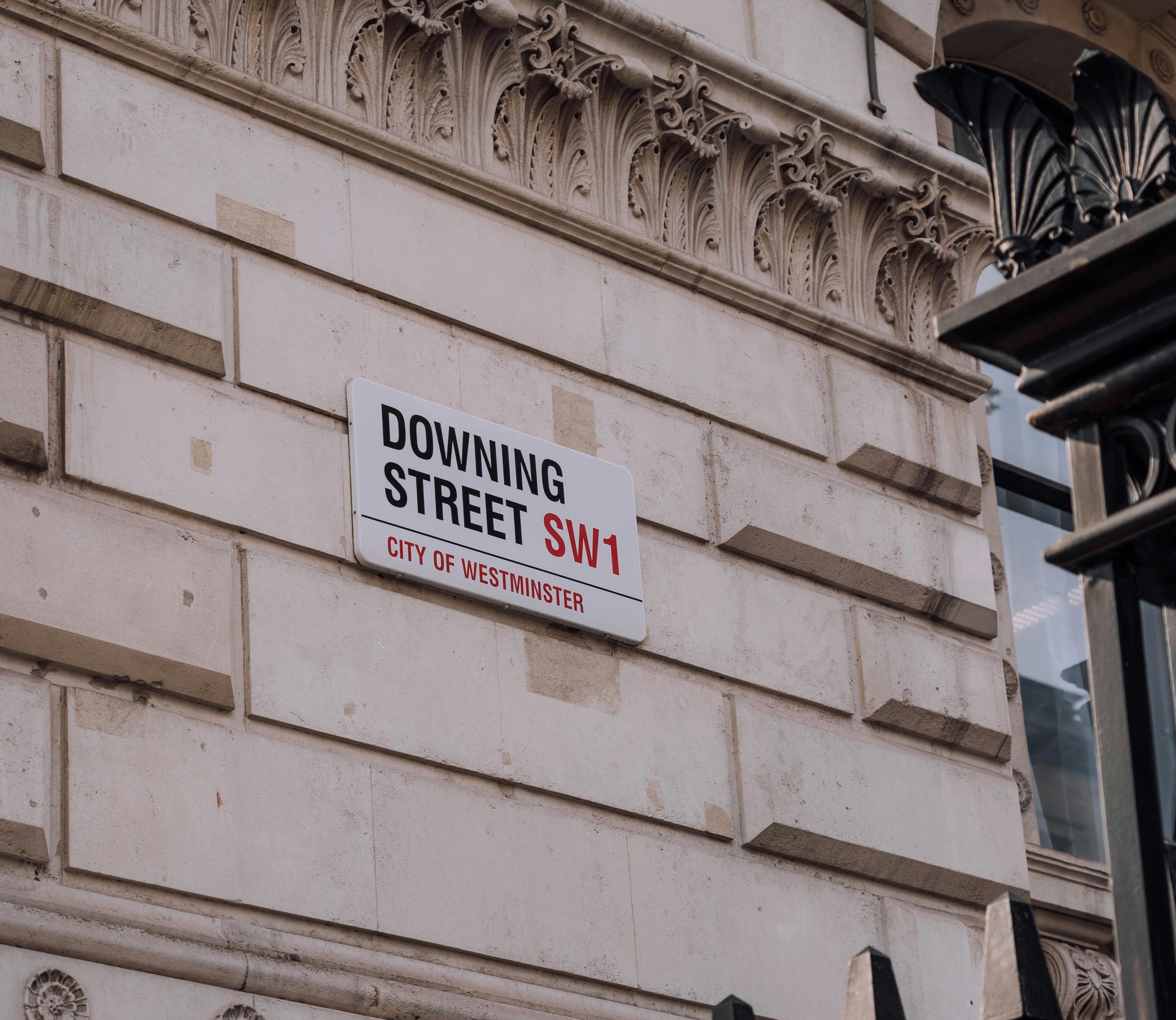 Road sign for Number 10 Downing Street on the side of the Cabinet Office on Whitehall.