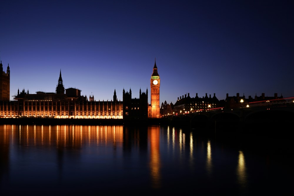 A photo of the Houses of Parliament in Westminster, London, UK, pictured at night.