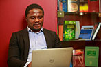 A man on his laptop next to some law books