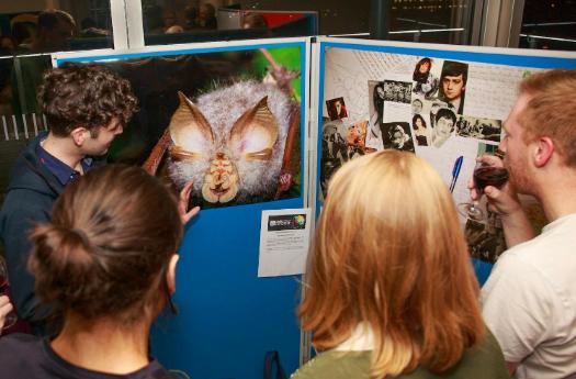 People standing in front of a poster presentation in discussion