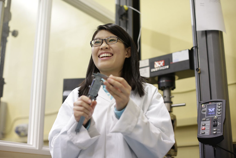 A scientist in a lab coat talks about a scientific instrument she is using