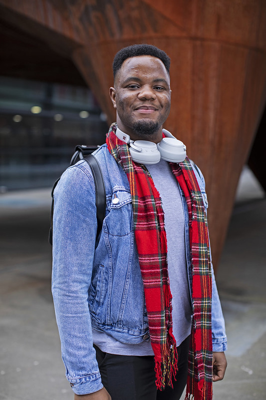 Student stands in front of a pillar